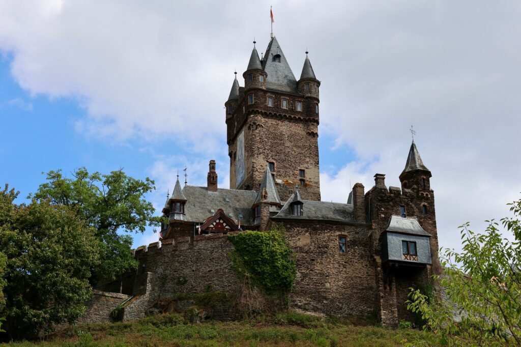 Reichsburg Cochem mit historischen Türmen auf einem bewaldeten Hügel